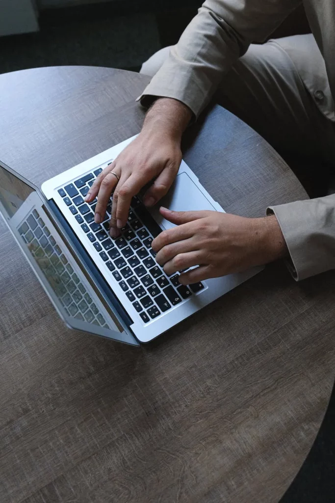 mans hands typing on laptop