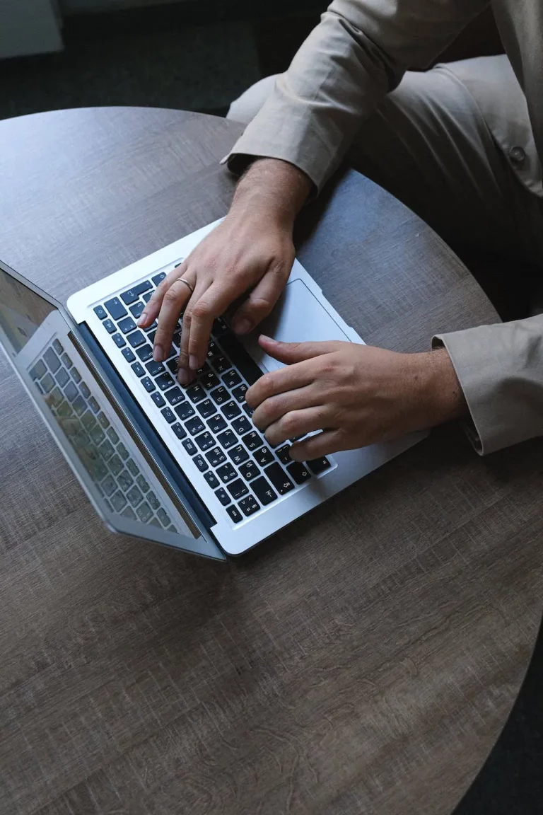 mans hands typing on laptop